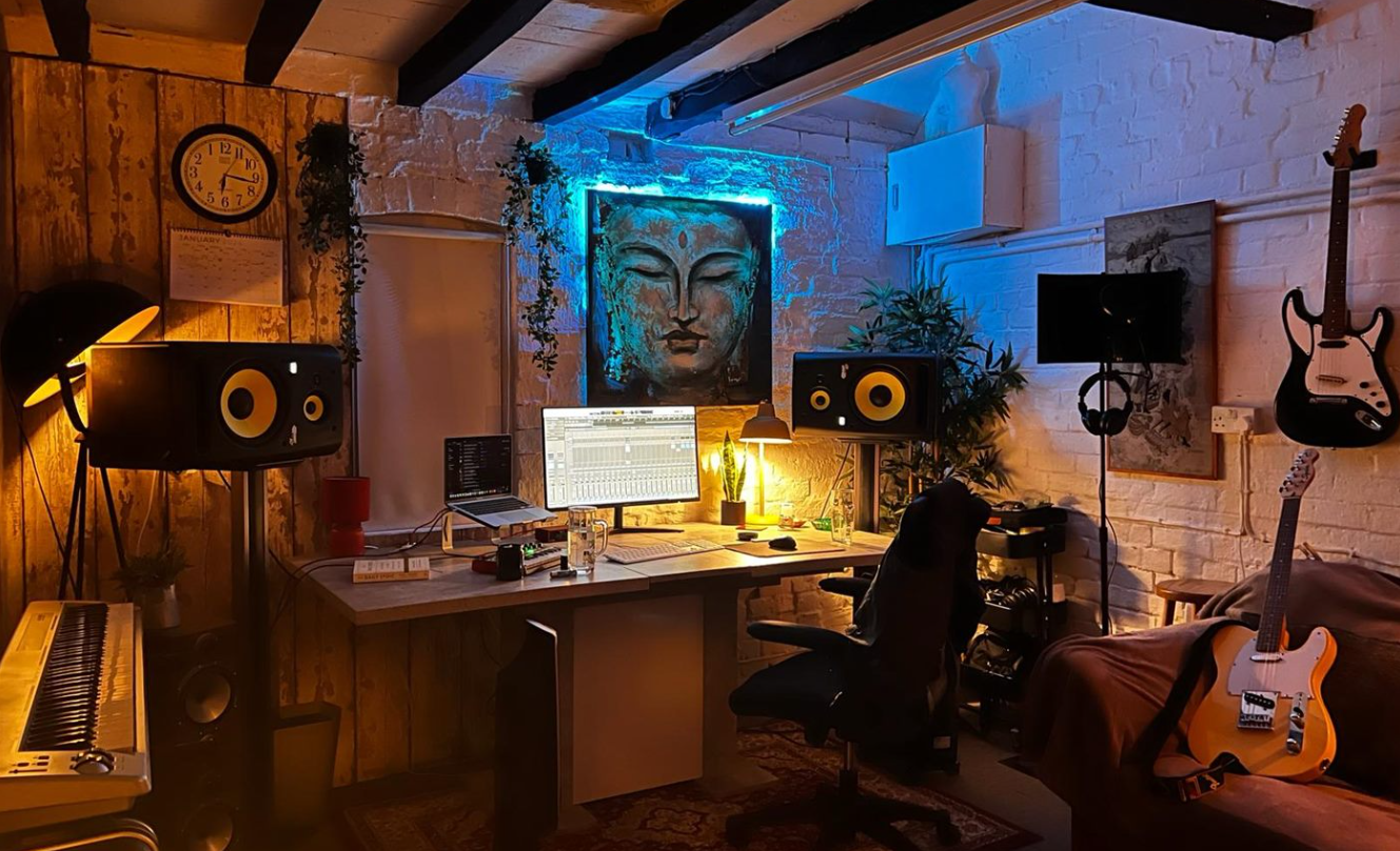 The control room at night, lit by warm lamps and a strip of blue light behind the artwork.